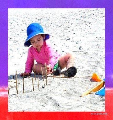 A baby playing in the sand